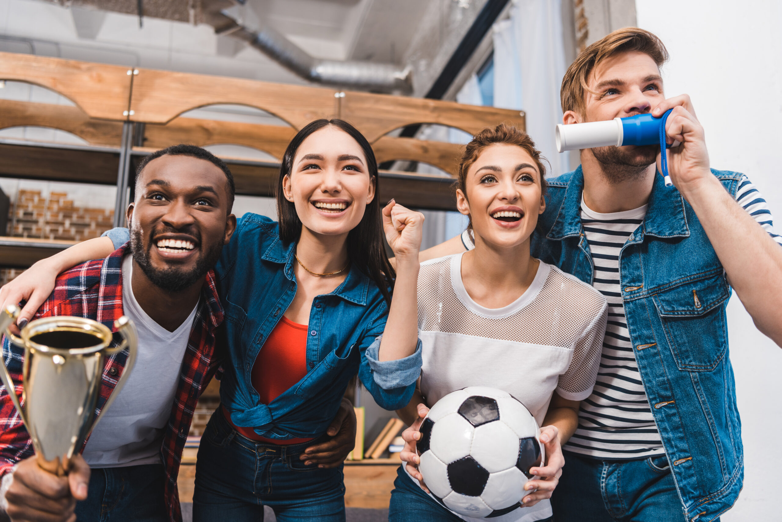 Jóvenes celebrando con entusiasmo durante un partido de fútbol