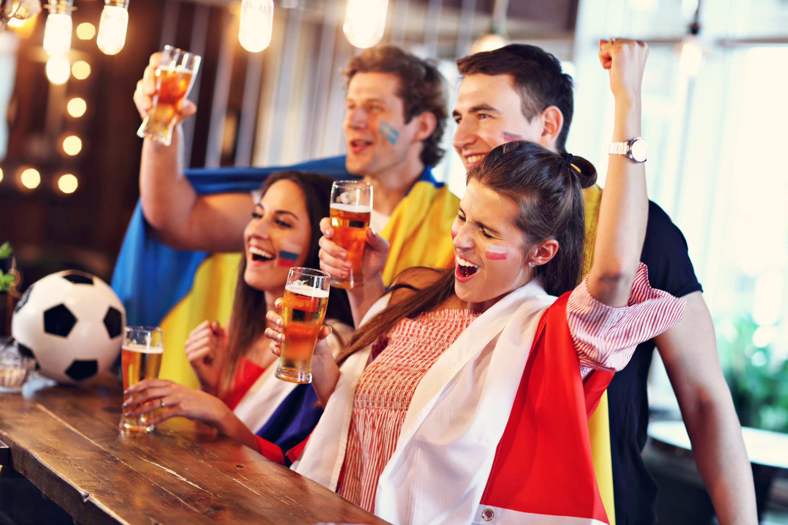 Grupo de amigos viendo fútbol en un pub